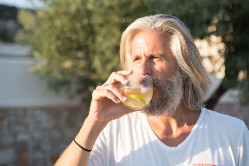 Homme dégustant une infusion Kokoraki dans un jardin